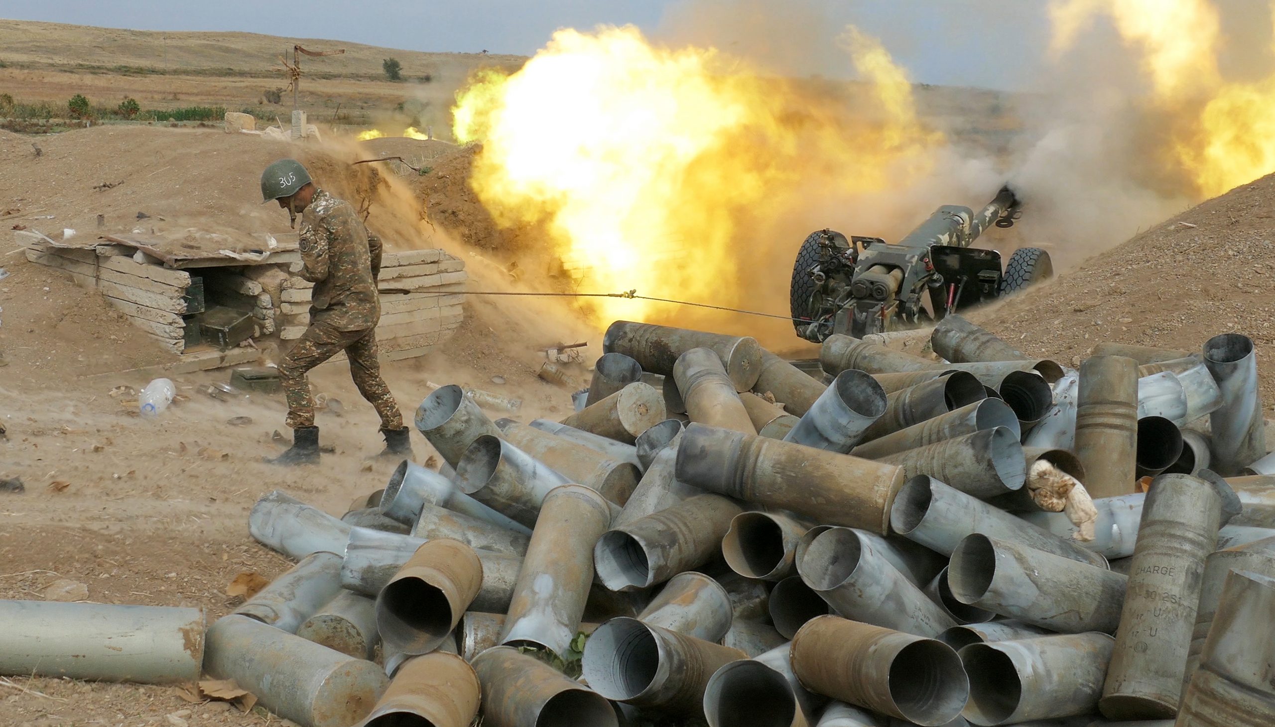 In this Sunday, Oct. 4, 2020 photo, an Armenian soldier fires an artillery piece during fighting with Azerbaijan's forces in self-proclaimed Republic of Nagorno-Karabakh, Azerbaijan. Sunday, Oct. 4, 2020. Heavy fighting between Azerbaijani and Armenian forces in the region since Sept. 27 has since killed scores of troops and civilians. Nagorno-Karabakh lies inside Azerbaijan but has been under the control of ethnic Armenian forces backed by Armenia since the end of a separatist war in 1994. The clashes have continued despite numerous international calls for a cease-fire.