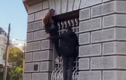 Žena se popela na ZGRADU PREDSEDNIŠTVA u Beogradu! Visi sa prozora, prolaznici u čudu